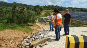 Construction defect. Alburquerque Mayor Efren Tungol inspects parts of the reconstruction works done on a retaining wall that caved in allegedly due to heavy rains in Barangay Dangay, Alburqueque, the site of the 6.9 has, Alburquerque Cluster Sanitary Landfill. (photo by Willie Maestrado)