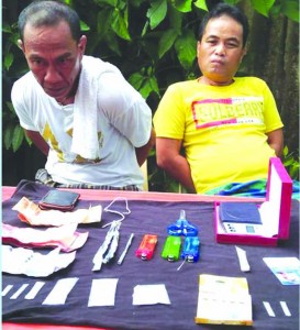 TANDEM. The latest to fall in the city's drug bust sequel, Roberto Amado (left) and Barangay Kagawad Emerlito Bastasa of Candabid, Maribojoc, yield three large packs of shabu that authorities consider a significant difference in the circulation of illegal drugs in the city. Foto: WELLIE MAESTRADO