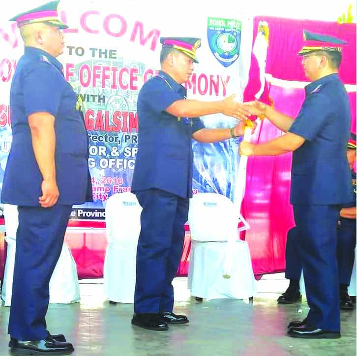 CHANGE OF GUARD. PS/Supt. Felipe Natividad (right) receives the Bohol PNP flag from PRO-7 Director Chief Supt. Noli TaliÃ±o (center) after P/SSupt. Dennis Agustin ends his tenure as Bohol PNP boss.